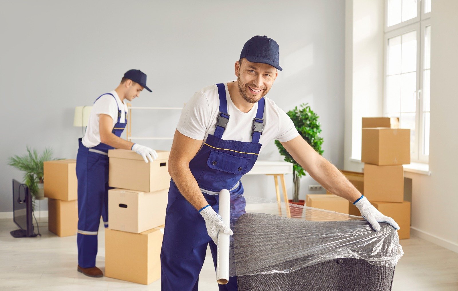Professional movers wrapping furniture